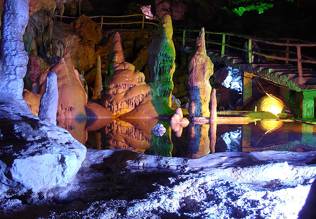 Colored lights play on stalagtites and stalagmites for a dramatic effect.