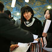 Job seekers hand in resumes at Beijing job fair. 