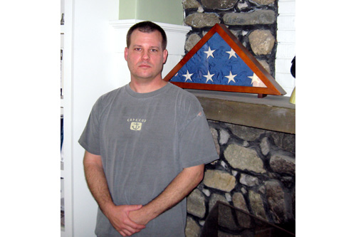 
                    Scott L'Ecuyer, a former chief engineer for a nuclear missile silo, stands next to the American flag that flew on his base. The flag is a reminder of a crew mate who succumbed to the pressure and took his own life.
                                            (Eric Molinsky)
                                        