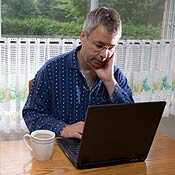 A man working on his laptop in his pajamas 