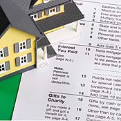 A yellow house sits on top of a tax form 