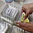 Woman puts labels on plastic containers.