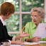 Elderly woman talks to financial adviser.