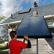 Workers install solar panels on a house 