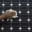 A worker cleans an assembled solar panel