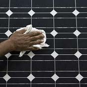A worker cleans an assembled solar panel 