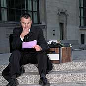 A man looks at his pink slip 