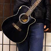 A busker holds his guitar 