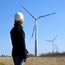 A worker stands in front of wind turbines