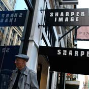 A pedestrian looks into Sharper Image store 