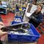 Employees work on a car parts production line