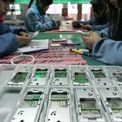 Workers check cell phones in a factory in China 