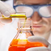 Lab worker pours liquid into a bottle. 