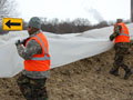 National Guard troops cover the dike in plastic