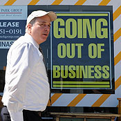 A man walks past a store going out of business 