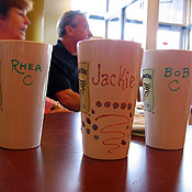 Members of the group drink coffee from personalized mugs.