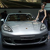 A woman poses with a Porsche Turbo 