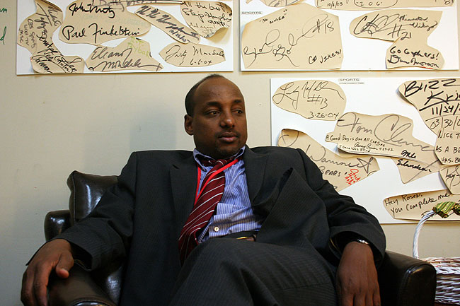 Community activist Omar Jamal waits in the makeup room of the WCCO-TV studio in Minneapolis before being interviewed by CBS News. Prominent Minnesotans, including Jamal, have signed their names on the walls surrounding him.