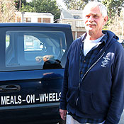 Frank Kolbash, assistant director at the St. Vincent Meals on Wheels Foundation, stands next to his delivery van.