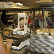 Volunteers and paid contractors assemble meals for clients.