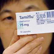A pharmacist displays a box of Tamiflu 