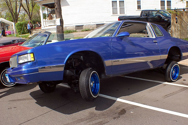 A lowrider sits on three wheels at a previous year's Cinco de Mayo car