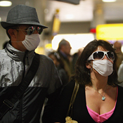 Travelers wear a surgical mask in London 