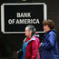 Pedestrians walk past a Bank of America branch
