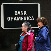 Pedestrians walk past a Bank of America branch 