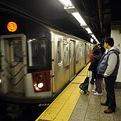 Commuters wait at a New York subway station 