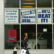People walk past a Chrysler dealership 