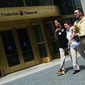 Pedestrians pass the Prudential building 
