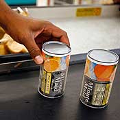 A checkout clerk prepares to bag frozen juice 