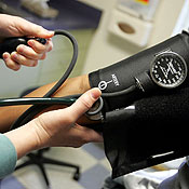A doctor reads a blood pressure gauge 