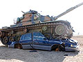 A tank crushes a car as part of a demonstration