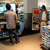 People look at a TV next to digital converters 