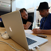Apple store worker helps customer with MacBook 