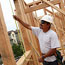A construction worker measures a window