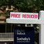 A realtor sign advertises a reduced price