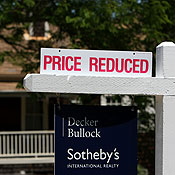 A realtor sign advertises a reduced price 