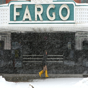 A pedestrian walks through falling snow in Fargo 
