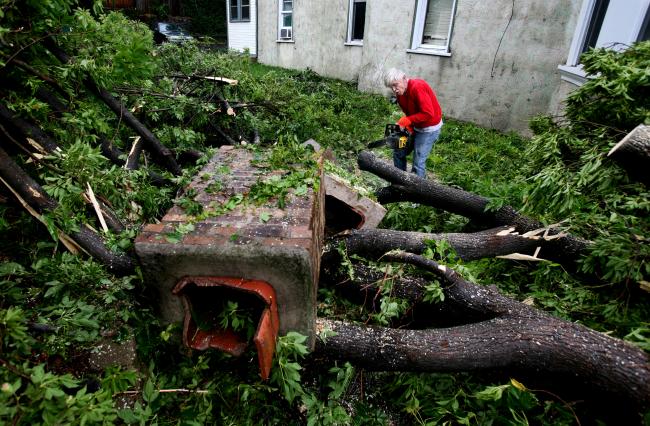 Emmett Winter works to clear a down tree at his Minneapolis property Wednesday, August 19, 2009.