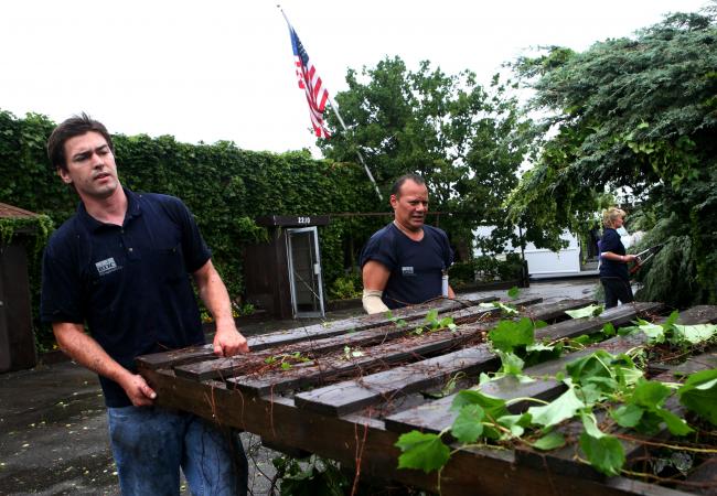 Charlie Fourness, left, and Steve Ramirez move a fence that blew down as severe weather moved through south Minneapolis Wednesday, August 19, 2009.