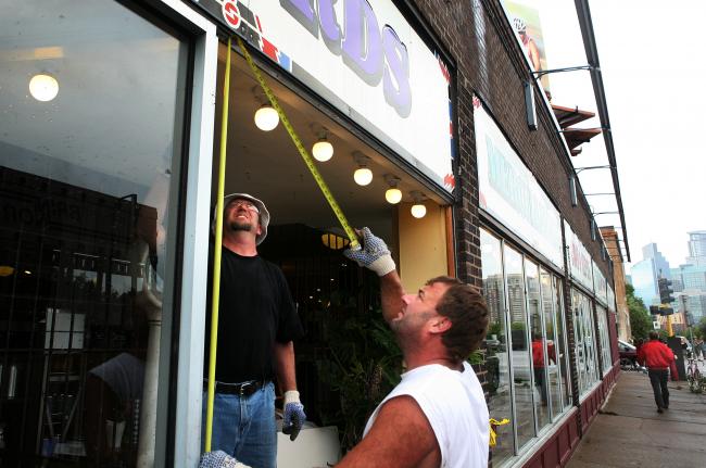 Craig Swanson and Tim Kazynski replace a broken window at the Electric Fetus in Minneapolis Wednesday, August 19, 2009.