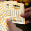 A man holds Mega Millions lottery tickets
