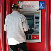 Bank customer uses ATM machine. 