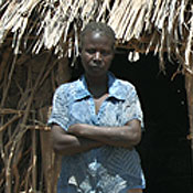 Margaret Akai lives in the community outside of Lodwar. She has nine children. They sleep in the huts behind her. One of her children shows visible signs of malnutrition.