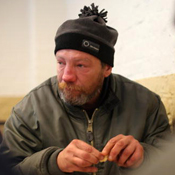 A homeless man eating hot soup. 