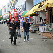 Foxconn Guanlan workers walk down a street filled with food joints.