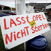 A sign reads 'Don't let Opel die' 